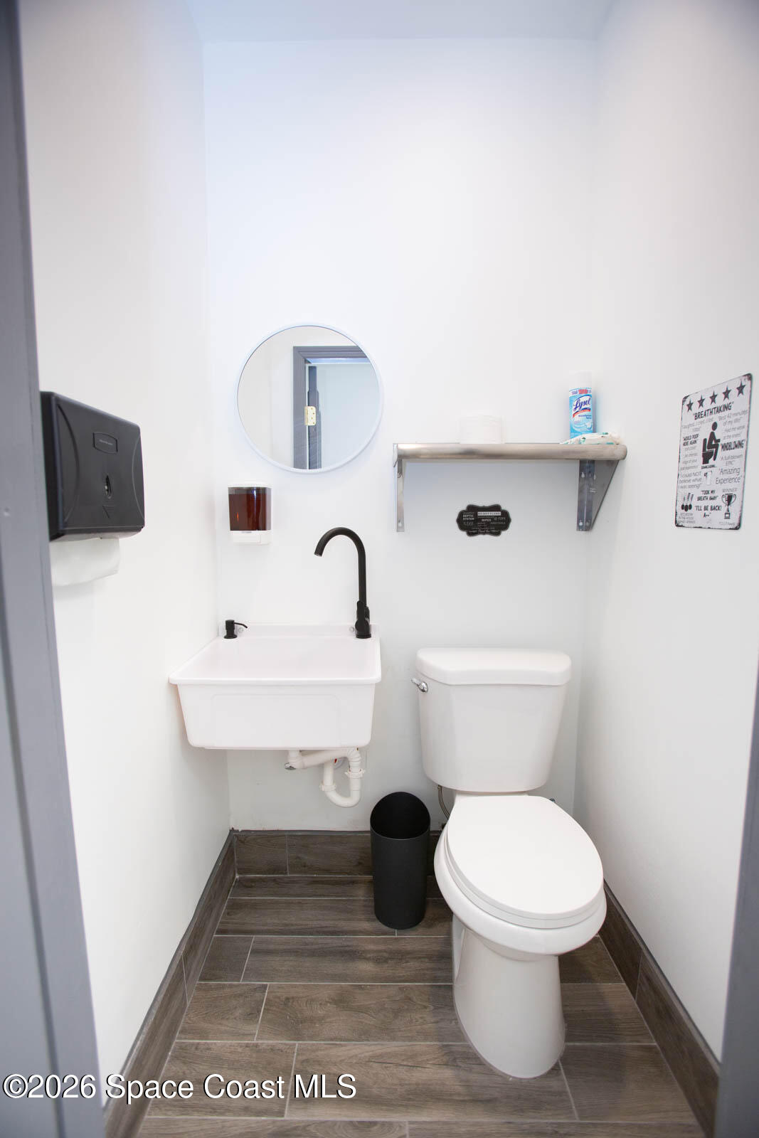411 Clearlake Road Cocoa, FL 32922 - Photo 8 of 25 a white toilet sitting next to a white sink and vanity