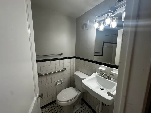 a bathroom with a toilet sink and mirror