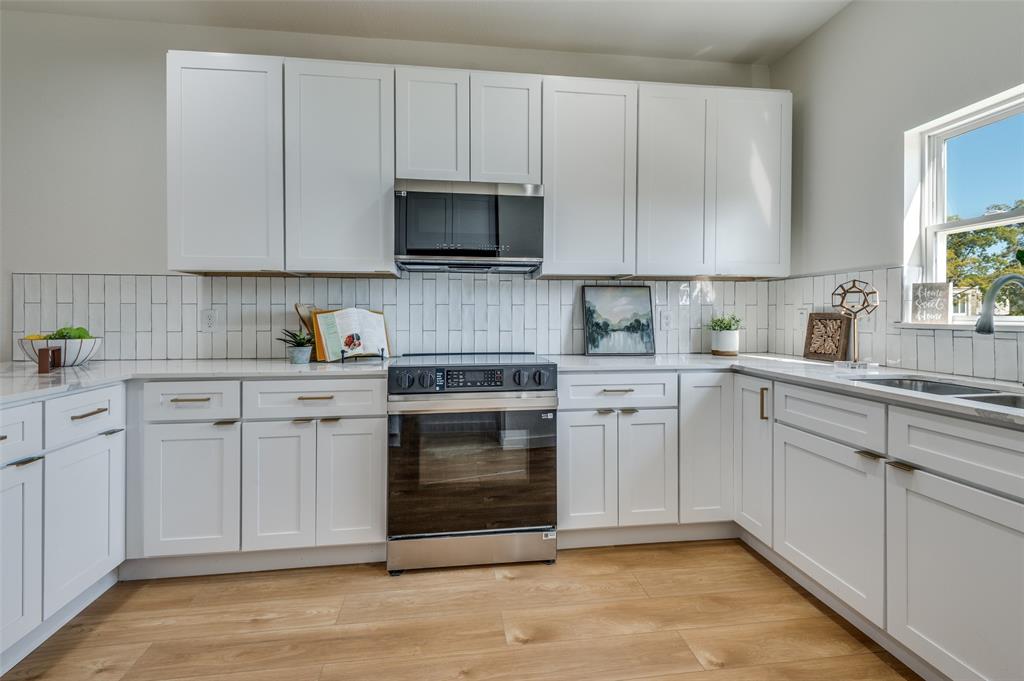 504 South O Connor Road Irving, TX 75060 - Photo 17 of 32 a kitchen with white cabinets stainless steel appliances and sink