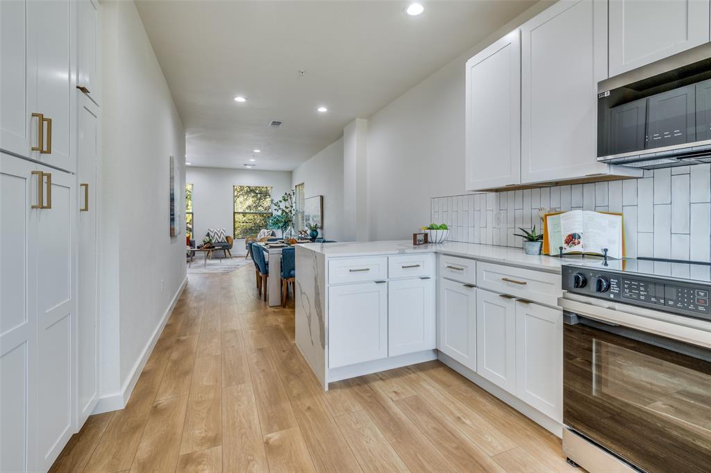 504 South O Connor Road Irving, TX 75060 - Photo 18 of 32 a kitchen with cabinets and wooden floor