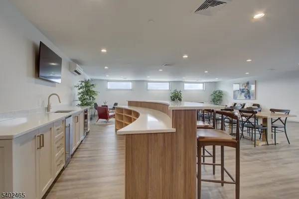 a kitchen with stainless steel appliances kitchen island granite countertop a table chairs and a refrigerator