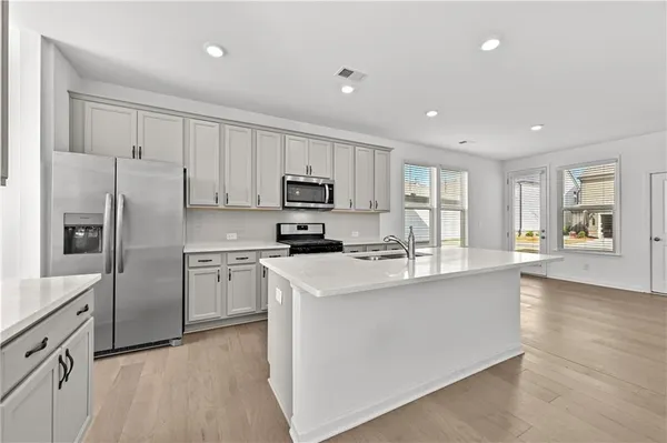 a kitchen with stainless steel appliances granite countertop a refrigerator a stove microwave and sink