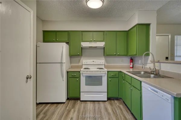 a kitchen with a refrigerator sink and cabinets