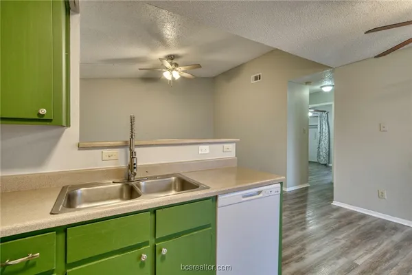 a kitchen with a sink cabinets and a wooden floor