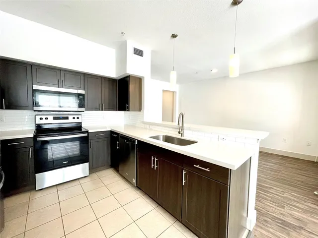 a kitchen with a sink a stove and cabinets