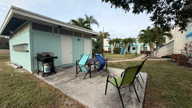 front view of house with a yard and palm trees