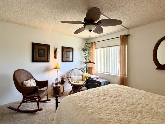 a bedroom with a bed a window and a chandelier