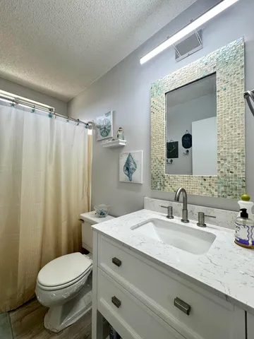 a bathroom with a granite countertop sink toilet and shower