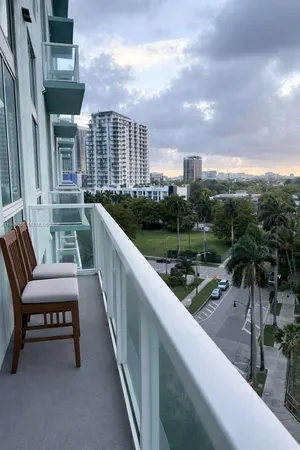 a view of swimming pool with a yard and palm trees