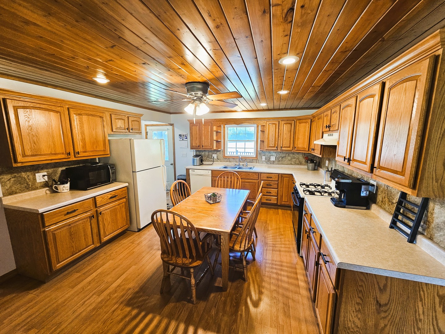 878 County Road 600N Sims, IL 62886 - Photo 21 of 39 a kitchen with stainless steel appliances granite countertop a stove a refrigerator a kitchen island a dining table and chairs with wooden floor