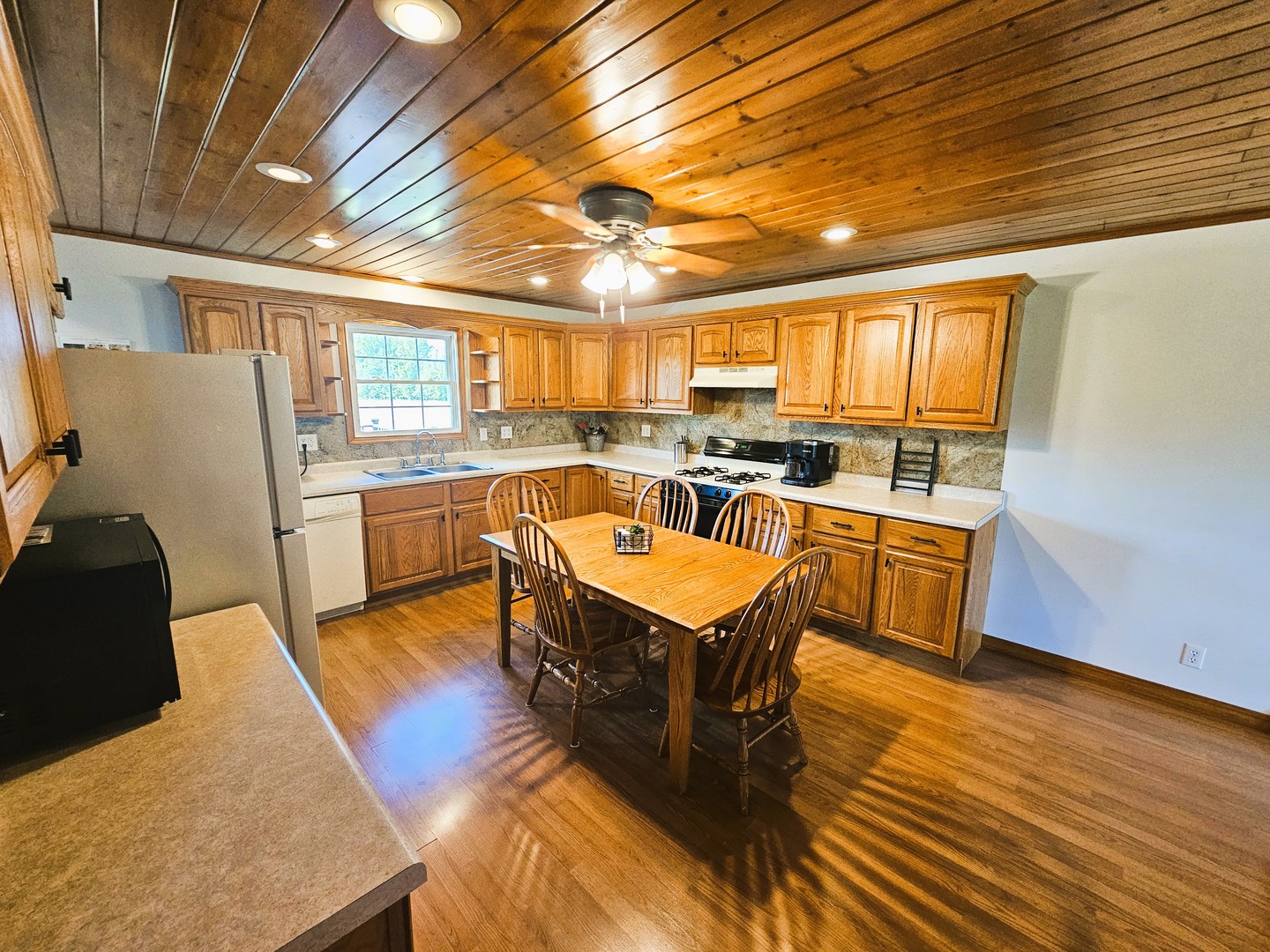 878 County Road 600N Sims, IL 62886 - Photo 22 of 39 a dining hall with stainless steel appliances granite countertop a stove a sink dishwasher and cabinets with wooden floor