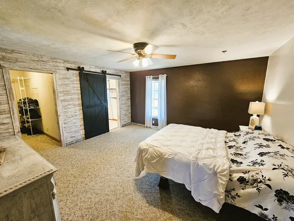 a spacious bedroom with a bed and a chandelier