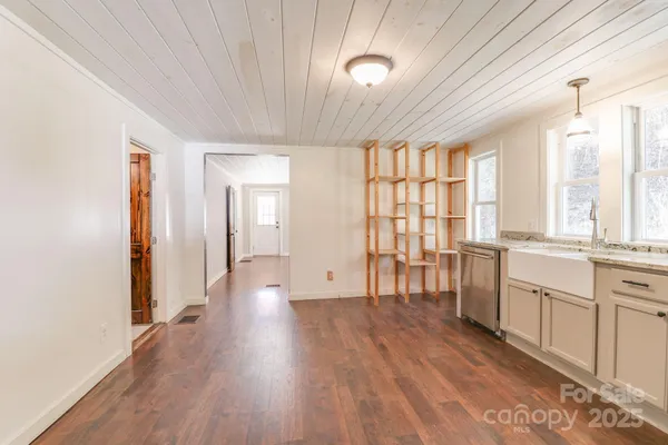 a kitchen with granite countertop a stove a sink a dining table and chairs