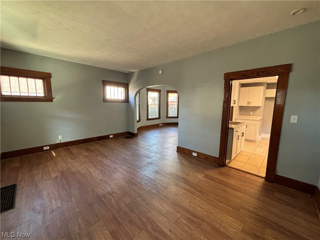 2711 11th Street Northwest Canton, OH 44708 - Photo 15 of 16 Empty room with light hardwood / wood-style floors, a textured ceiling, and a healthy amount of sunlight