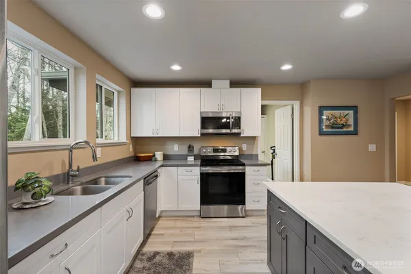 a kitchen with stainless steel appliances granite countertop a sink stove and refrigerator