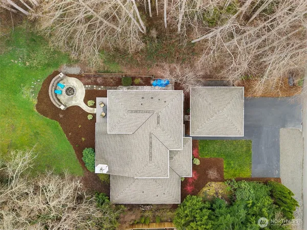 an aerial view of a house with a yard and a large tree
