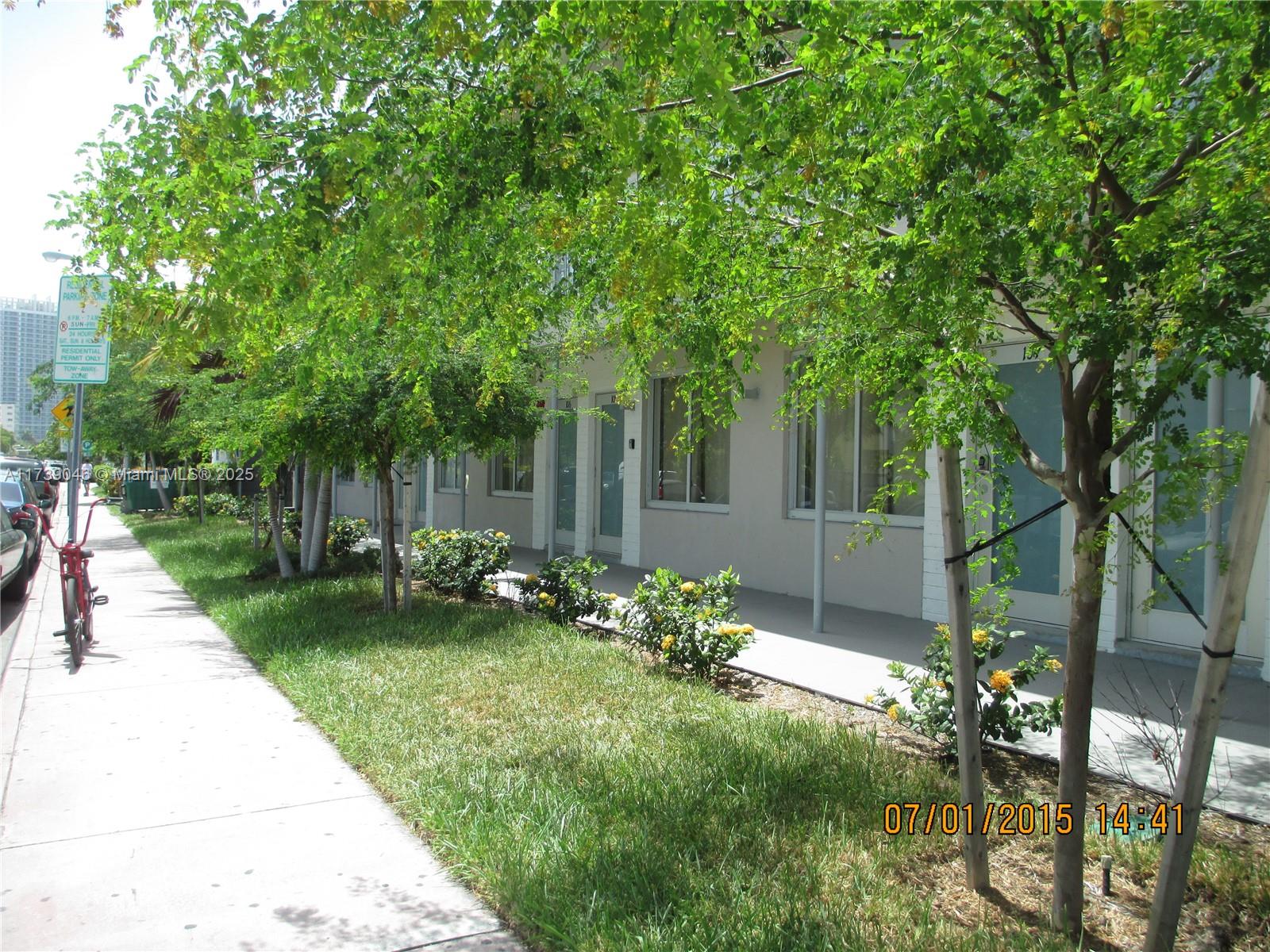 801 15th Street, Unit 109 Miami Beach, FL 33139 - Photo 1 of 9 a view of a backyard with table and chairs and potted plants and large trees