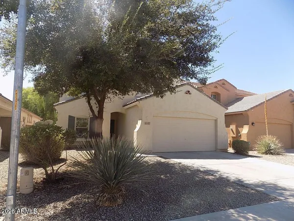 a view of a white house next to a road and yard