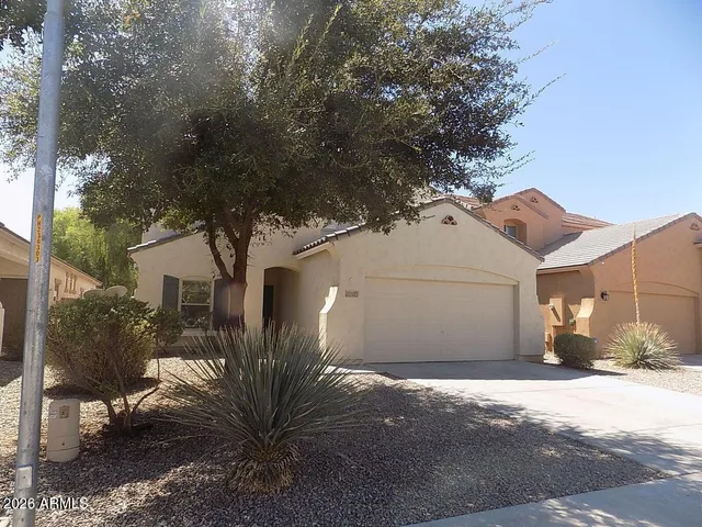 a view of a white house next to a road and yard