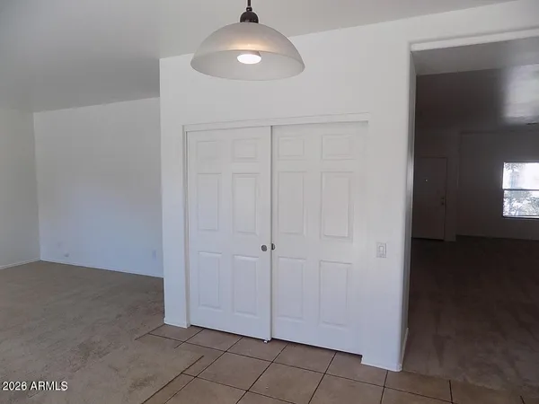 an empty room with wooden floor cabinet and windows