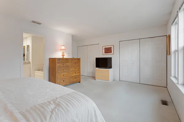 a large bedroom with a bed and a view of bathroom