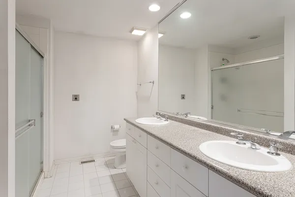 a bathroom with a granite countertop sink a toilet and a mirror
