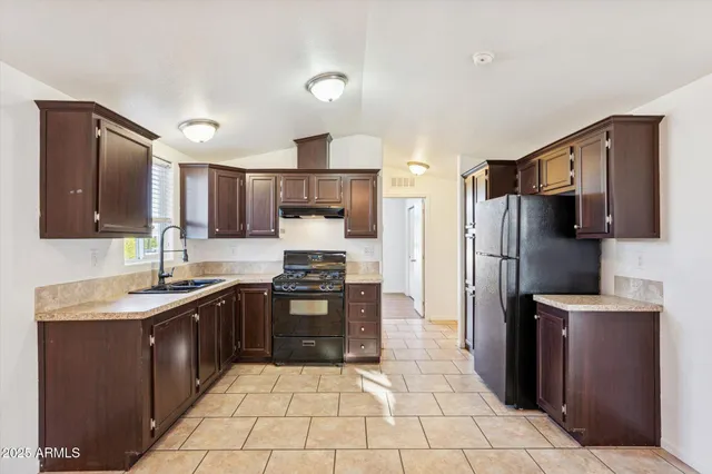 a kitchen with stainless steel appliances granite countertop a refrigerator and a stove
