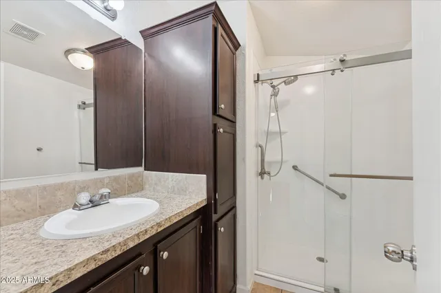 a bathroom with a granite countertop sink mirror and shower