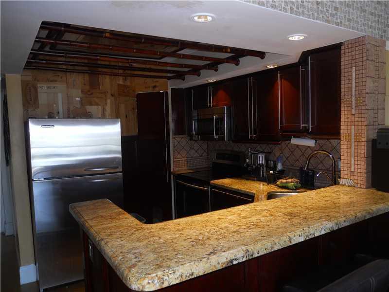 5321 Northeast 24th Terrace, Unit 512A Fort Lauderdale, FL 33308 - Photo 7 of 18 a kitchen with granite countertop stainless steel appliances and wooden cabinets