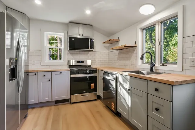 a kitchen with stainless steel appliances granite countertop a sink stove and refrigerator