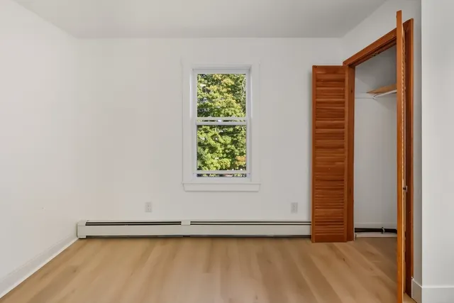 a view of a small space with wooden floor and a window