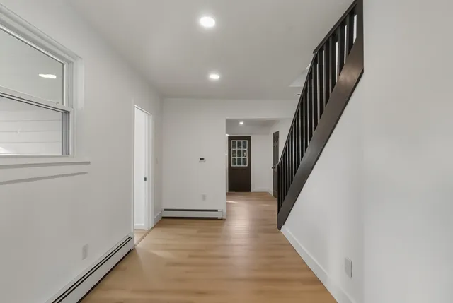 a view of a hallway with wooden floor and staircase