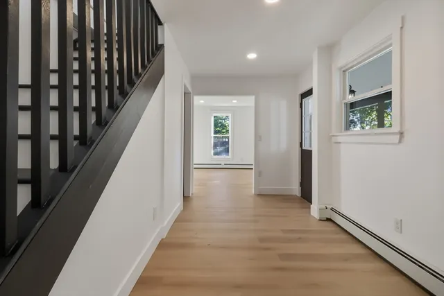 a view of a hallway with wooden floor and staircase