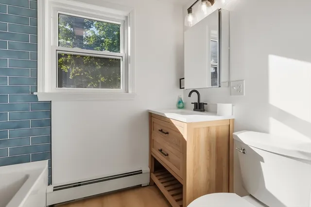 a bathroom with a toilet sink and mirror