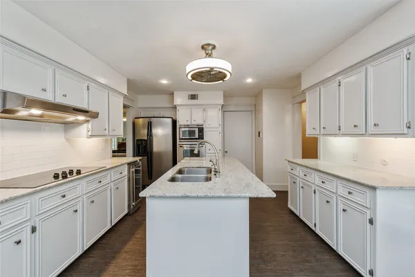 a kitchen with stainless steel appliances granite countertop a sink stove oven and white cabinets