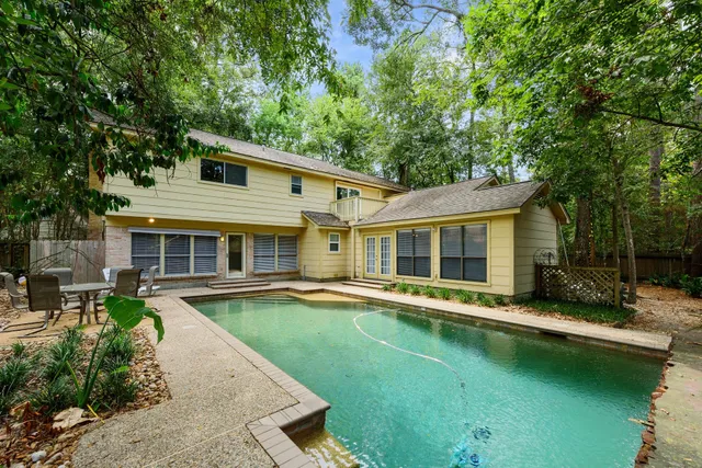 a view of a house with a yard patio and swimming pool
