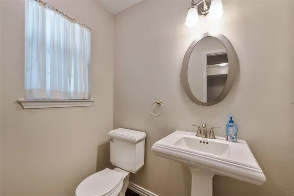 a bathroom with a sink mirror and toilet