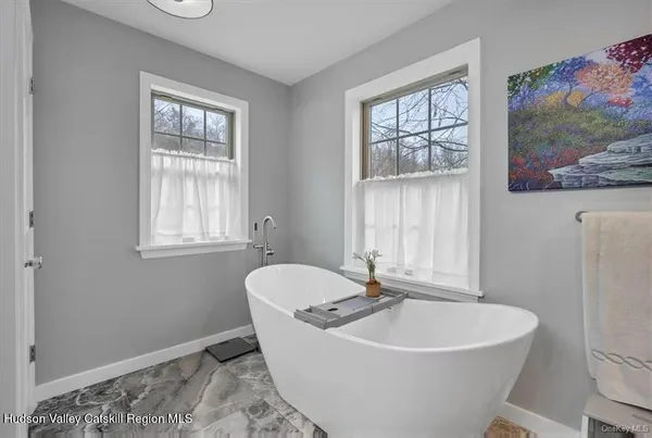 a white bath tub sitting in a bathroom next to a window
