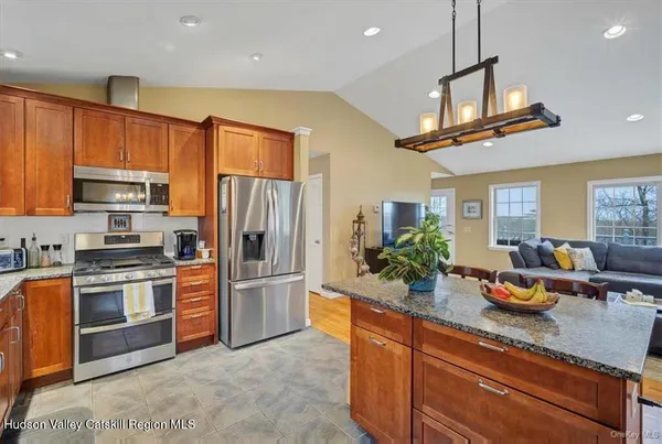 a kitchen with stainless steel appliances granite countertop a sink a stove and a refrigerator
