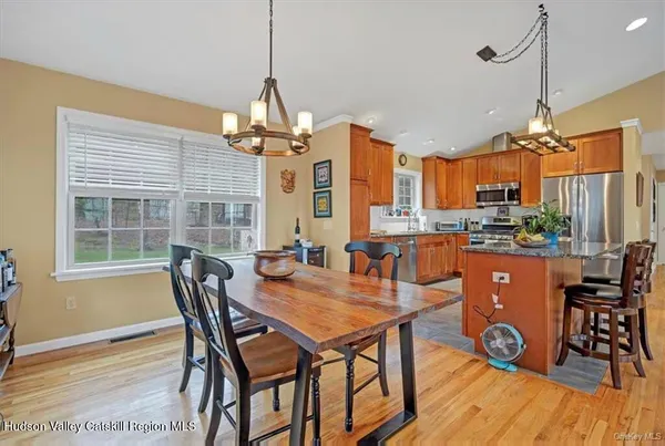 a dining room with furniture a chandelier and wooden floor