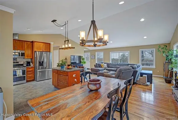 a dining room with wooden floor a chandelier a wooden table and chairs