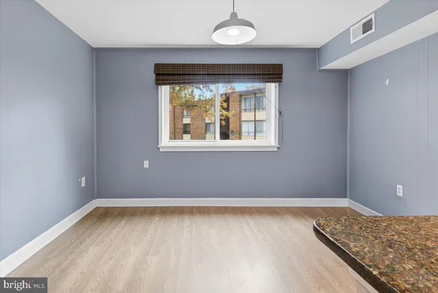 an empty room with window and hallway