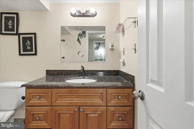 a bathroom with a granite countertop sink and a mirror
