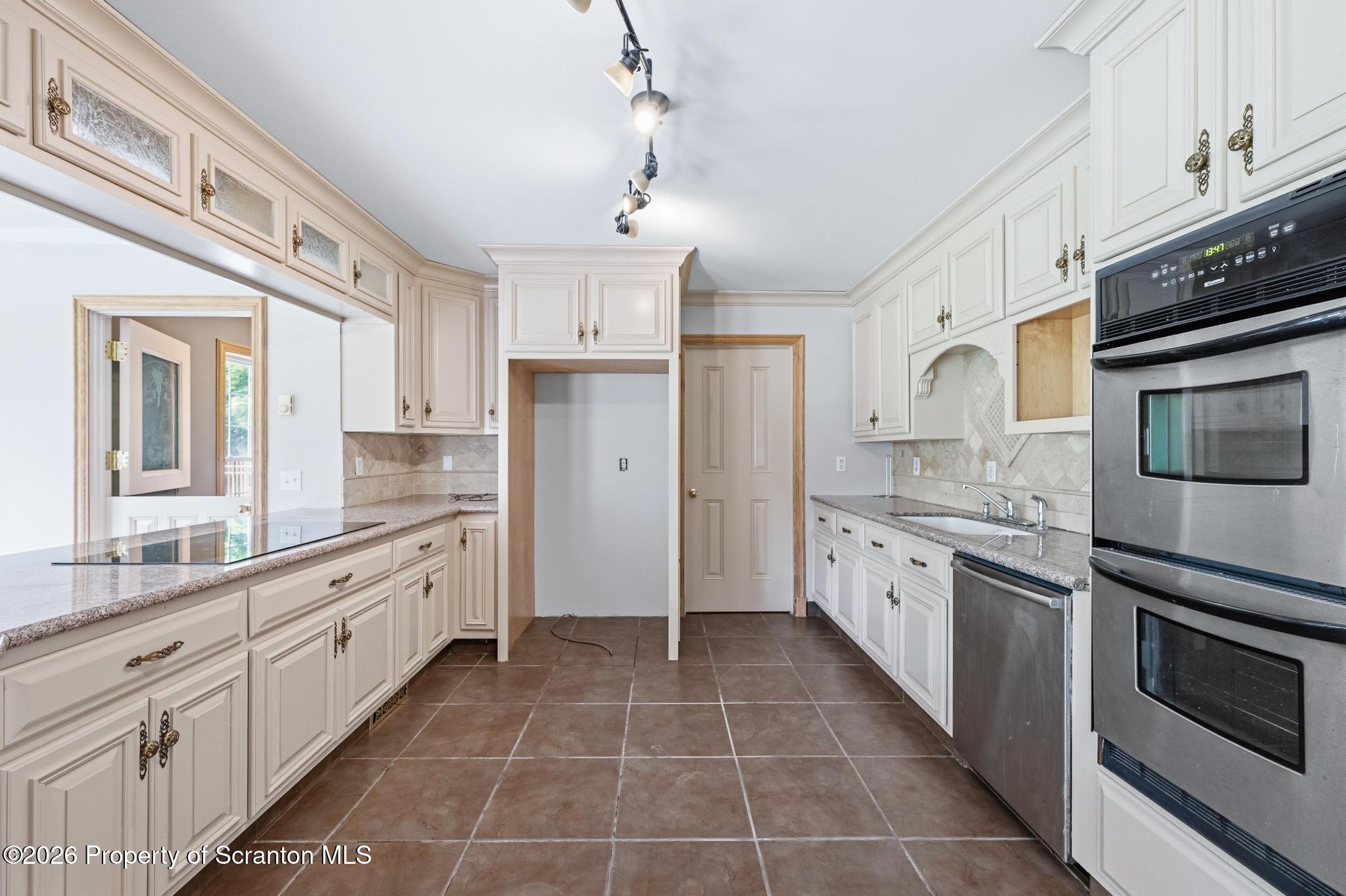 116 Forge Street Old Forge, PA 18518 - Photo 8 of 49 a large kitchen with cabinets stainless steel appliances and a window