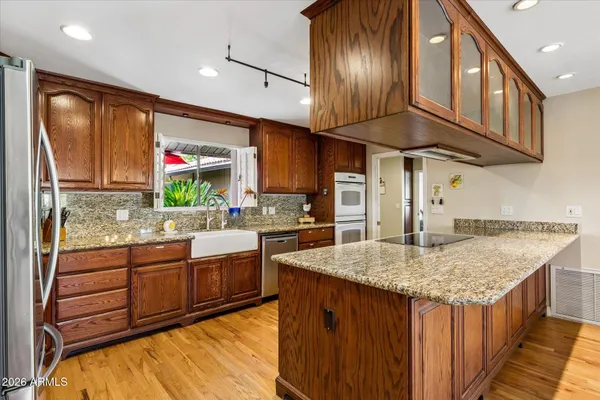 a kitchen with stainless steel appliances granite countertop a sink a stove and a refrigerator