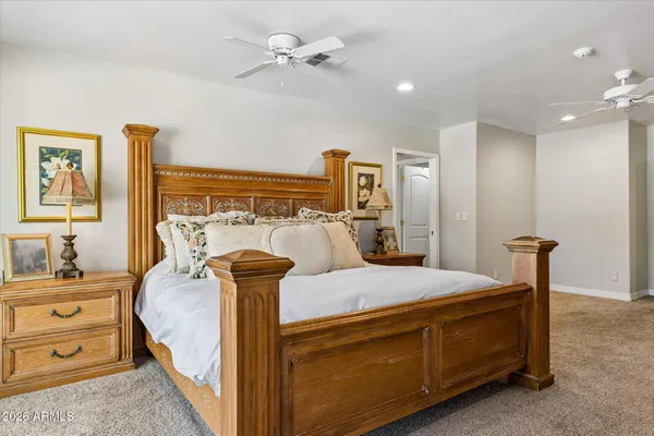 a room with a bed and a chandelier fan