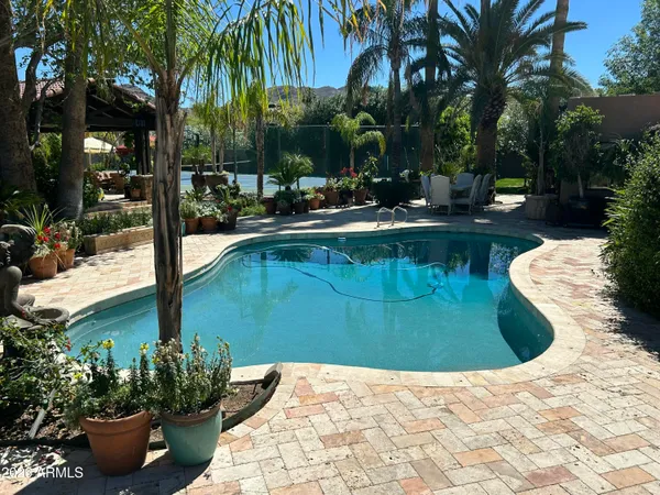 a view of a house with a yard and palm trees