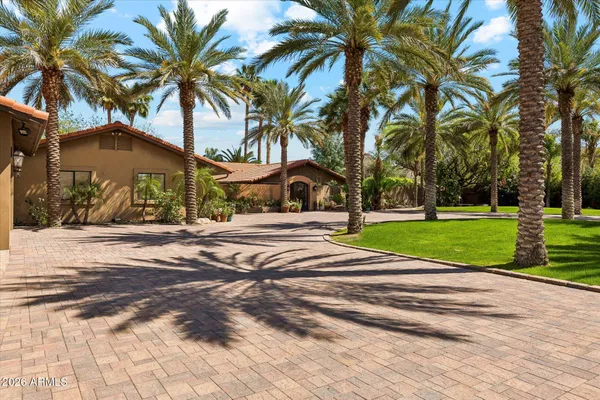 a view of a house with a yard and palm trees