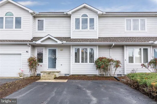 a front view of a house with a yard and a garage