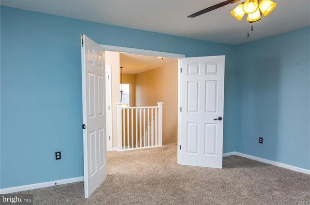 an empty room with a window and chandelier